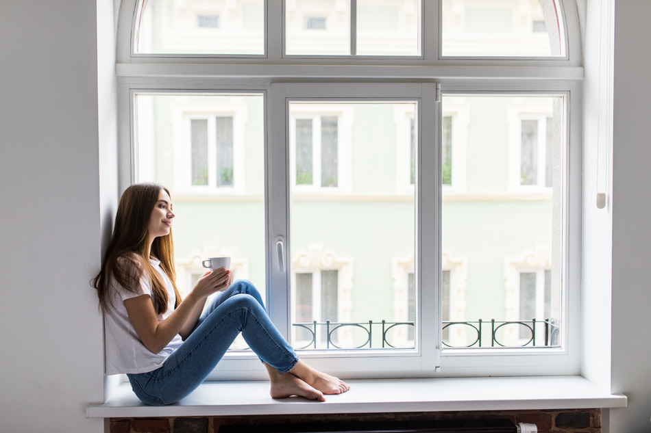 Kobieta siedząca przy oknie PVC